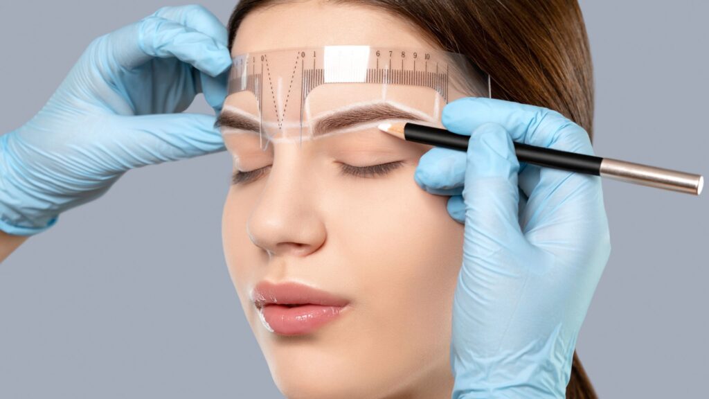 Woman getting her face measured in preparation for eyebrow microblading.
