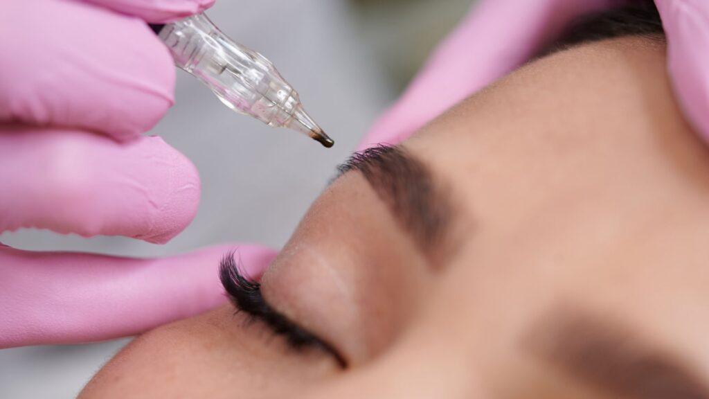 Woman getting microblading done on her eyebrows.