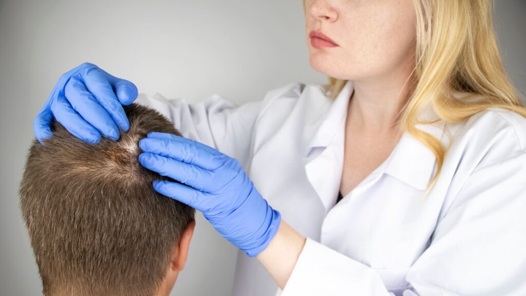 Person examining a patient's scalp
